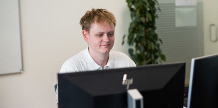 Portræt af Casper foran en computer